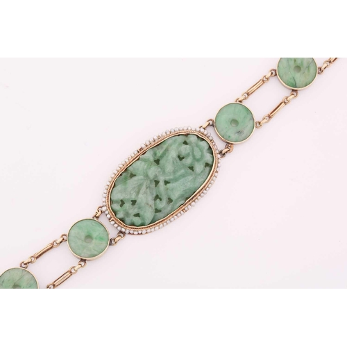 20 - A carved jade and pearl bracelet, featuring an elongated oval jadeite plaque in a greyish-green colo... 