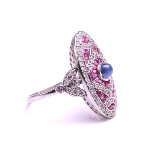 205 - An art deco style oval panel ring set with a Sapphire and Rubies, the central cabochon Sapphire meas... 