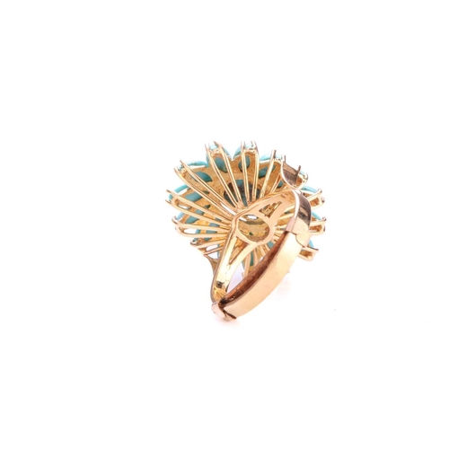 218 - A turquoise flowerhead ring, comprises a high-domed turquoise cabochon claw set in the centre, surro... 