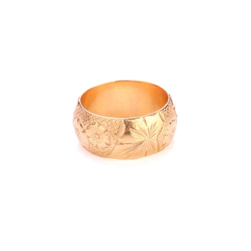 225 - A 22ct yellow gold ring, the thick D-section band has been engraved with floral designs throughout, ... 