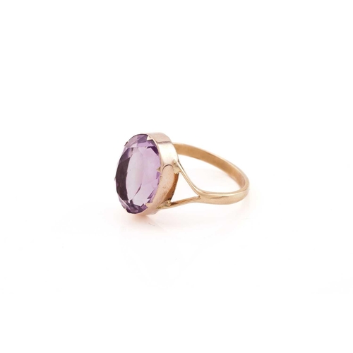 23 - An amethyst ring, consisting of an oval-cut amethyst approximately measures 14.5 x 11.2 mm, claw col... 