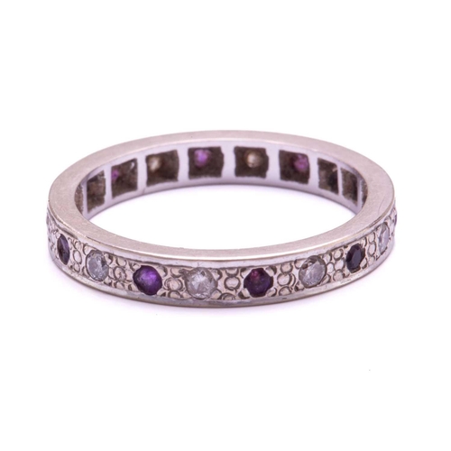 239 - A rhodolite garnet and diamond eternity ring, with round faceted purple garnets alternating with bri... 