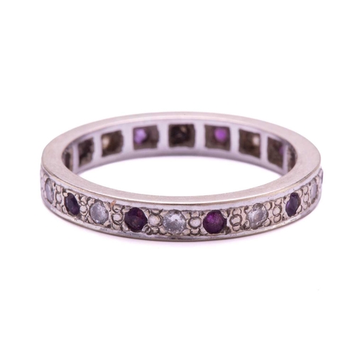 239 - A rhodolite garnet and diamond eternity ring, with round faceted purple garnets alternating with bri... 