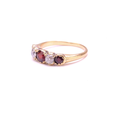 251 - A Garnet and Diamond five-stone ring, set with a central red Garnet flanked by two old round diamond... 