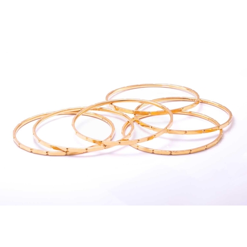 256 - A suite of six yellow metal bangles, with a faceted design, yellow metal unmarked (tests 18ct gold o... 