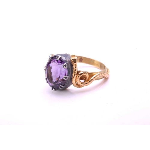 272 - An amethyst dress ring with 18ct gold and silver, comprises an oval-cut amethyst in silver open-back... 