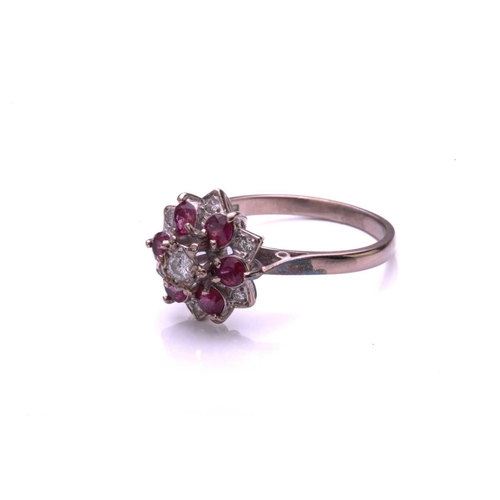 28 - A ruby and diamond cluster ring, comprising a central round brilliant cut diamond above a border of ... 