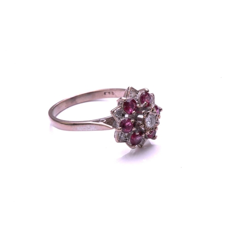 28 - A ruby and diamond cluster ring, comprising a central round brilliant cut diamond above a border of ... 