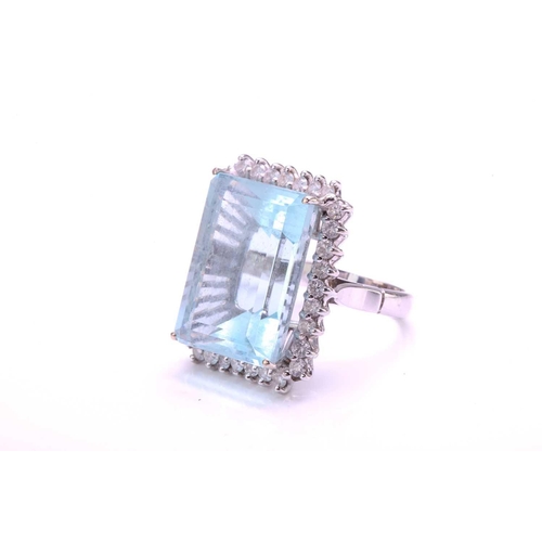 292 - A large aquamarine and diamond cluster ring, featuring a rectangular step-cut aquamarine with pale b... 