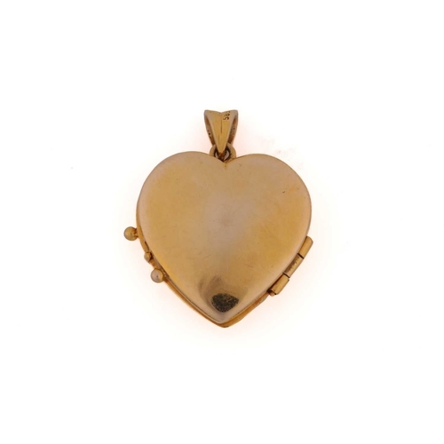 293 - An emerald and diamond set heart-shaped locket; hinged, with a diagonal band of three calibré cut em... 