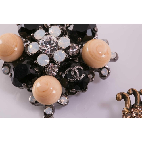 302 - Two costume brooches; to include a Chanel two-toned cluster brooch with a drop decoration, signed 'C... 