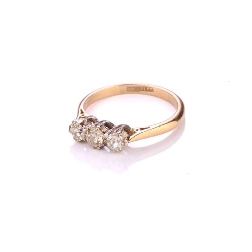 304 - A three-stone diamond ring, consisting of three old-cut diamonds with a light yellow tint, in corone... 