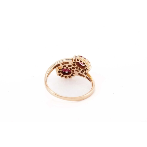 308 - A ruby and diamond bypass ring, composed of two clusters of oval faceted rubies surrounded by brilli... 