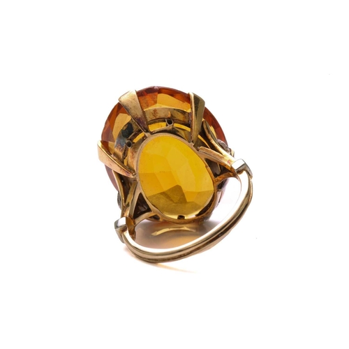 35 - A large citrine dress ring in 18ct yellow gold, featuring an oval-shaped mixed-cut citrine with deep... 