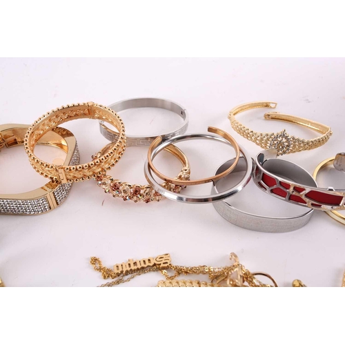 38 - A quantity of assorted base metal costume jewellery comprising various hinged bangles, line bracelet... 