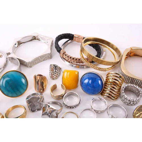 38 - A quantity of assorted base metal costume jewellery comprising various hinged bangles, line bracelet... 