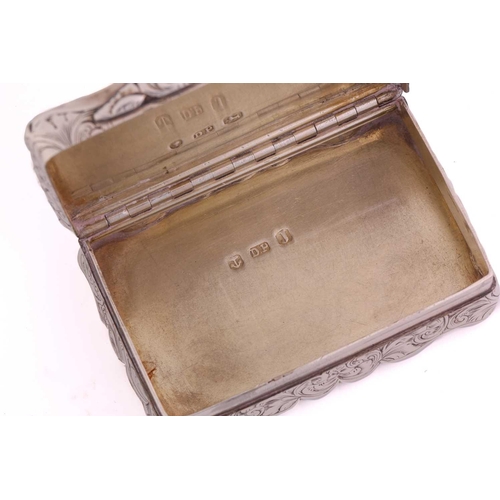 427 - A Victorian silver snuff box of shaped rectangular form allover decorated with scrolling flowering f... 