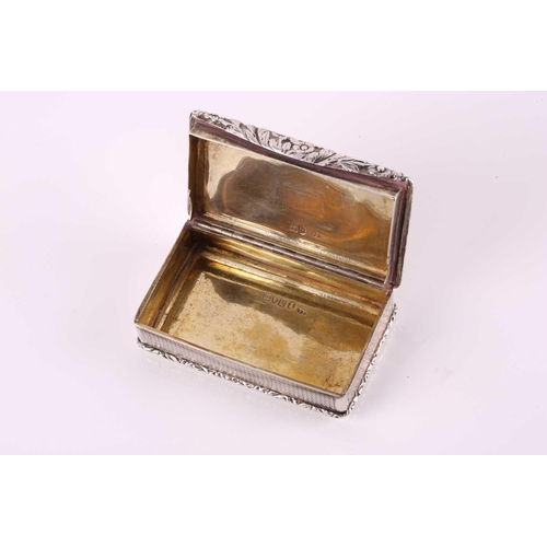 428 - A George IV silver snuff box, rounded rectangular with applied, cast foliate border, engine-turned c... 