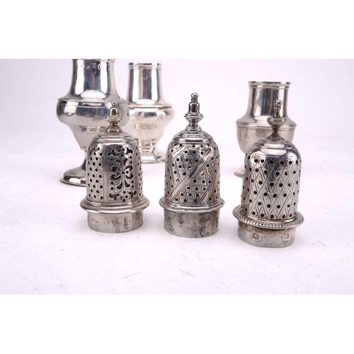 455 - Three George III silver sugar casters each with a spool knop and of baluster form with flared foot, ... 