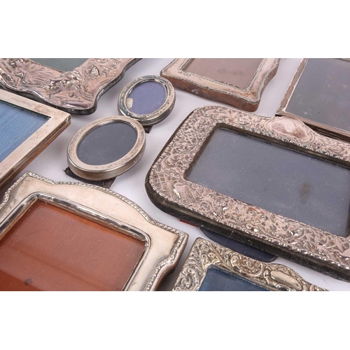 467 - A collection of twelve silver fronted easel photograph frames including , a modern embossed photo fr... 