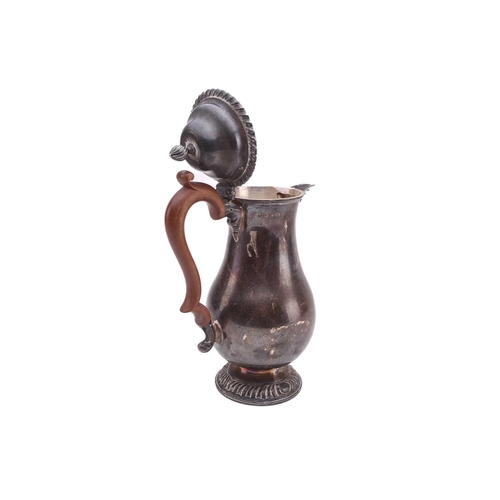 475 - A silver hot water jug; baluster form with gadrooned borders and beaded mount to spout, wooden scrol... 