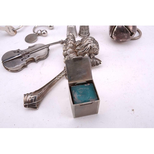 493 - A collection of silver and white metal comprising a miniature flask with screw cover, a silver match... 