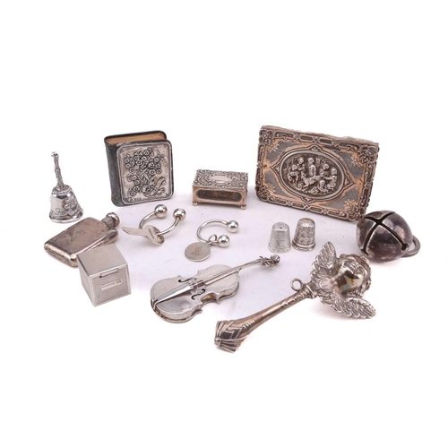 493 - A collection of silver and white metal comprising a miniature flask with screw cover, a silver match... 