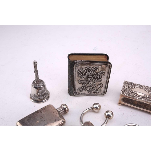 493 - A collection of silver and white metal comprising a miniature flask with screw cover, a silver match... 