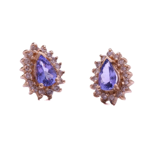 52 - A tanzanite and diamond cluster ring and a pair of matching earrings; the ring comprises an oval tan... 