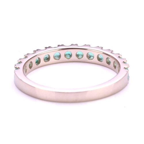 67 - An emerald half eternity ring, consisting of fourteen circular-cut emeralds in U-cut pavé settings, ... 