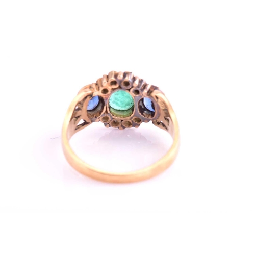 7 - An Emerald and Sapphire dress ring, consisting of a central rub-over set oval emerald measuring 6x5.... 