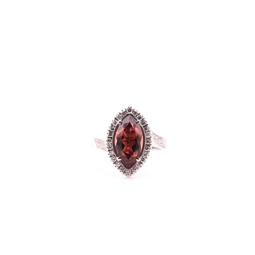 70 - A tourmaline and diamond cluster ring; the marquise-shaped tourmaline set within a border of round b... 