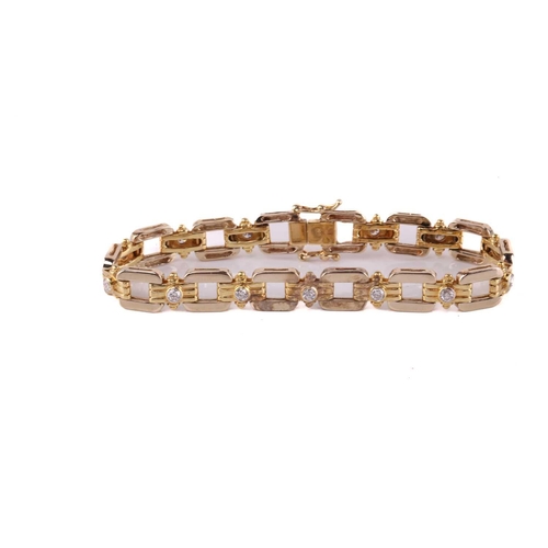 74 - A bi-coloured, diamond set, open link bracelet; the polished rounded rectangular links with reeded r... 