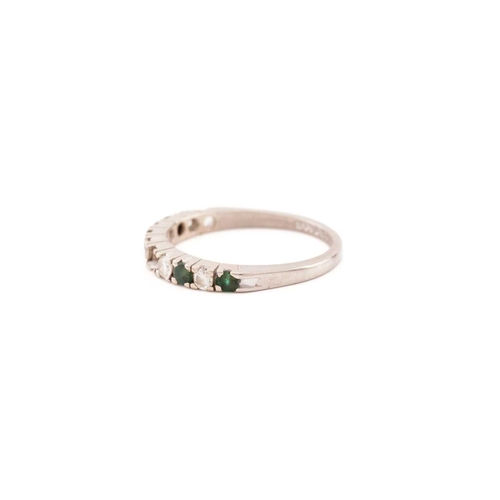 84 - An emerald and diamond half eternity ring in 18ct white gold, comprises five round brilliant-cut dia... 