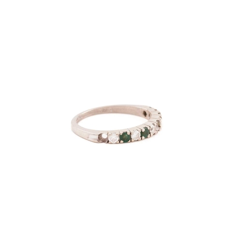 84 - An emerald and diamond half eternity ring in 18ct white gold, comprises five round brilliant-cut dia... 