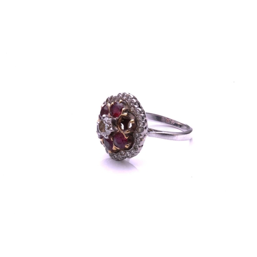 93 - A ruby and diamond cluster ring; the principal round brilliant cut diamond in a raised claw mount ab... 