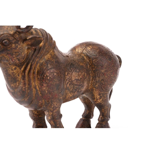 203 - A Chinese patinated and gilt bronze figure of an Oxen with curled horns and a body engraved with fla... 