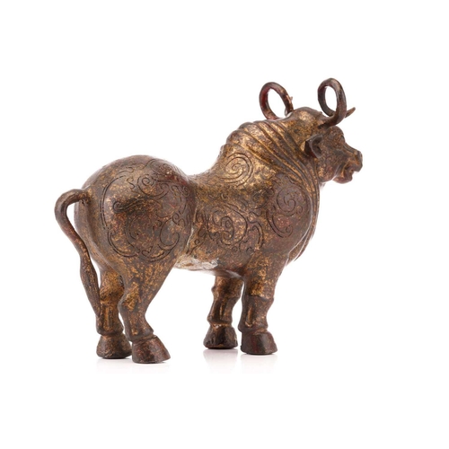 203 - A Chinese patinated and gilt bronze figure of an Oxen with curled horns and a body engraved with fla... 