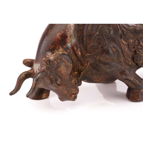 207 - A Chinese patinated and gilt bronze figure of a charging bull with cash bridle and saddle cloth. 27 ... 