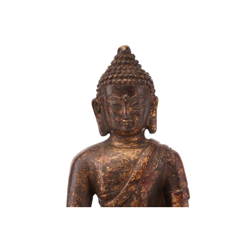 212 - A patinated and gilt bronze figure of a Tibetan-style Buddha seated in dhyansana mudra upon a double... 