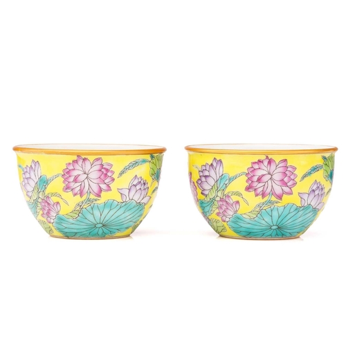 221 - A pair of Chinese porcelain tea bowls, the exterior painted with lotus flowers and leaves against ye... 