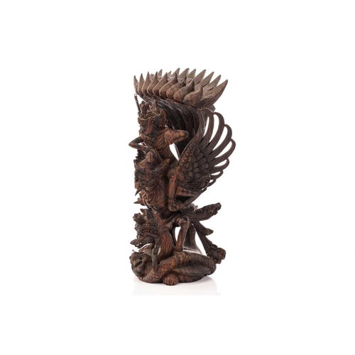 222 - A Balinese-carved and pierced hardwood figure of Vishnu riding on his mount; the winged Garuda, who ... 