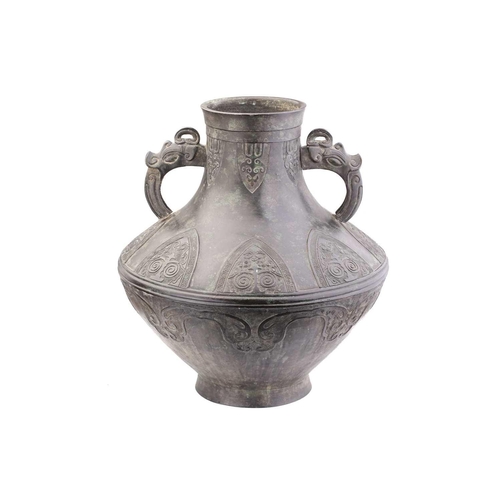 228 - A Chinese Archaic form bronze two handled urn with zoomorphic loop handles, the body with ruyi, clou... 