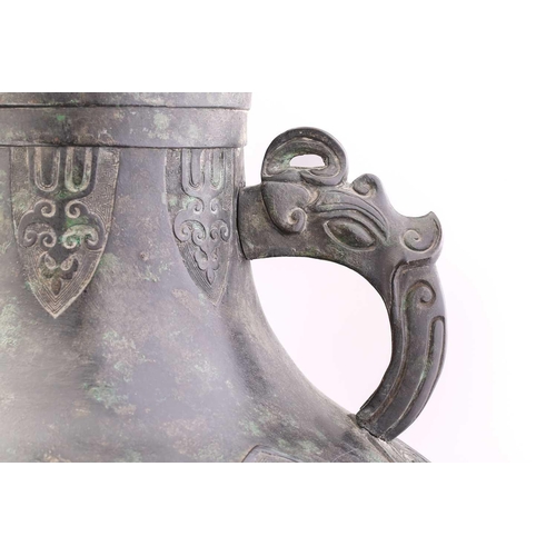 228 - A Chinese Archaic form bronze two handled urn with zoomorphic loop handles, the body with ruyi, clou... 