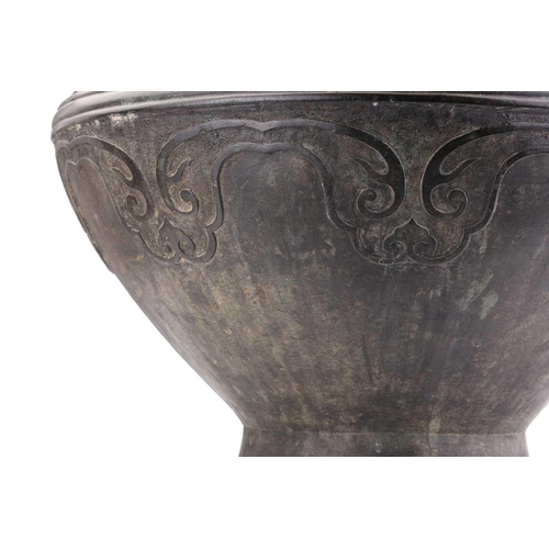 228 - A Chinese Archaic form bronze two handled urn with zoomorphic loop handles, the body with ruyi, clou... 