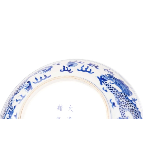 234 - A pair of Chinese porcelain blue & white 'Dragon' dishes, painted with a writhing dragon chasing a p... 