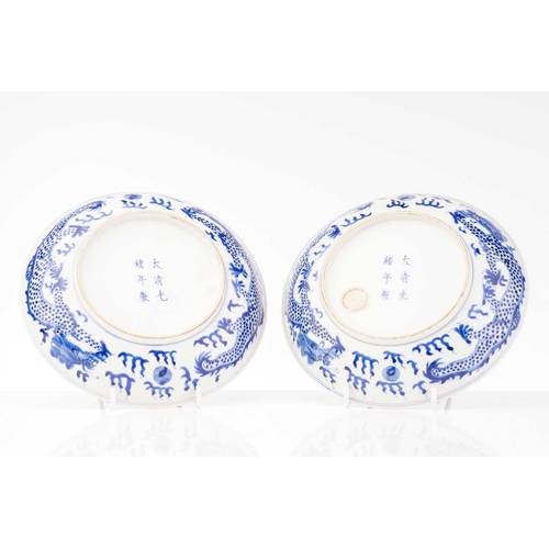 234 - A pair of Chinese porcelain blue & white 'Dragon' dishes, painted with a writhing dragon chasing a p... 