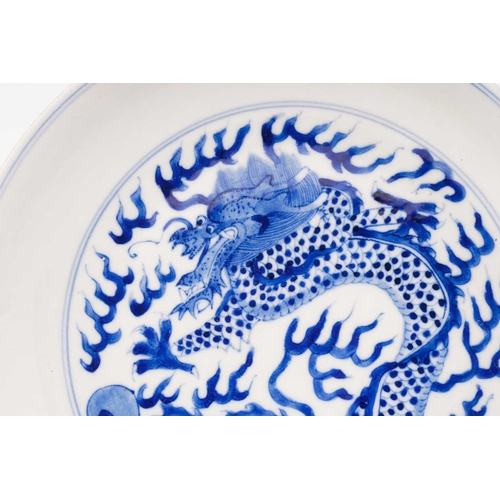 234 - A pair of Chinese porcelain blue & white 'Dragon' dishes, painted with a writhing dragon chasing a p... 