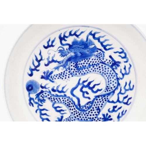 234 - A pair of Chinese porcelain blue & white 'Dragon' dishes, painted with a writhing dragon chasing a p... 