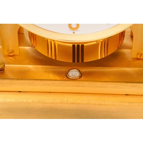 300 - A Jaeger LeCoultre brushed brass Atmos clock, no. 453672, with Arabic numerals at the quarter chapte... 